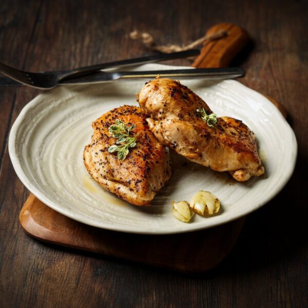 Couple of cooked chicken fillets on a plate.