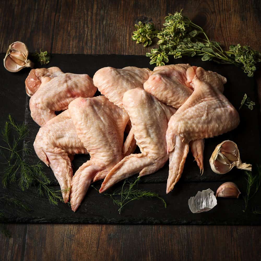 Selection of chicken wings displayed on a dark wooden platter.