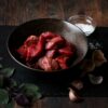 Diced braising beef in dark coloured bowl.