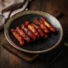 pigs in blankets served on a plate with a rustic bark background