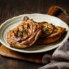 Two slices of pork loin steak served on a white plate