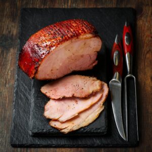 Roasted gammon served on a black stone board, sliced